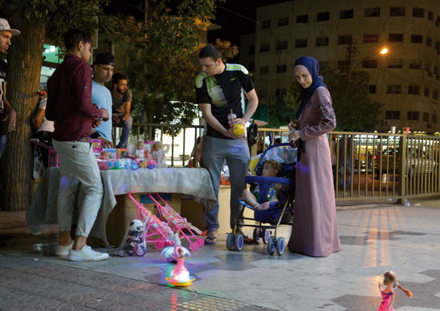 A vendor sells toys on a sidewalk in Amman on Sunday (Photo by Amjad Ghsoun)